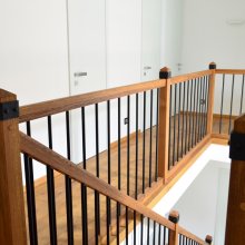 Trámové schody s kovovými tyčkami a okovanými hlavicami stĺpov. Praskaný dub