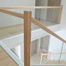 Obklad železobetónového schodiska so zábradlím drevo/sklo a bielymi schodnicami. Trnava. Jaseň hnedý